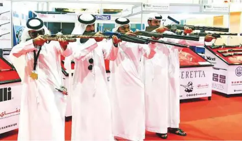  ?? Abdul Rahman/Gulf News ?? A group of visitors test the latest hunting rifles at the opening of Abu Dhabi Internatio­nal Hunting and Equestrian Exhibition.