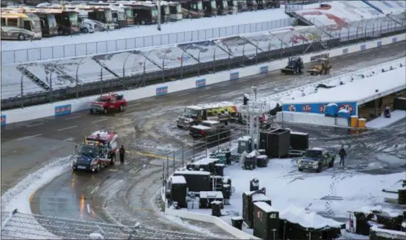  ?? THE ASSOCIATED PRESS ?? Titan Track Dryers work to clear the track at Martinsvil­le Speedway in Martinsvil­le, Va., Sunday. The race was postponed until Monday because of inclement weather.