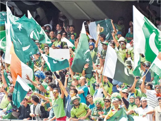  ??  ?? Flying the flag: Pakistan supporters dance and shout slogans prior to the 2015 World Cup match against India at the Adelaide Oval. Right, India’s wicketkeep­er Mahendra Singh Dhoni (centre) and Ravindra Jadeja (right) appeal for a catch behind against Pakistan’s Umar Akmal (left) during the same match