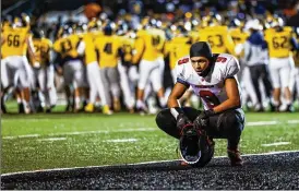  ?? NICK GRAHAM / STAFF ?? Malik Hartford reflects on Lakota West’s regional final loss as victorious Moeller celebrates in the background Friday at Dwire Field in Mason.