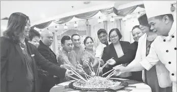  ??  ?? Hotel Grand Continenta­l management and hotel staff tossing ‘yee sang’ at the hotel yesterday. Evelyn is at fourth right.