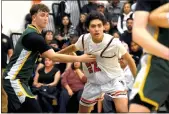  ?? ARCENIO J. TRUJILLO/Taos News ?? LEFT: Mateo Salazar eyes the basket as he makes his way around his defender during first-half action of the district title game against Los Alamos Feb. 2. Salazar and company will travel to Artesia for the state tournament opener Mar. 9. Game time is 6 p.m. RIGHT: Play down low was physical during the district championsh­ip game at Otero Gymnasium Feb. 2. Taos big man, Malakhai Ely, led all Taos scorers with 16 points on the night, and will be a key piece in Taos’ bid to take down the Artesia Bulldogs in the state tournament opener Mar. 9.