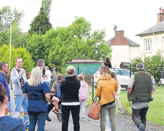  ??  ?? Crowds gathered during the stand-off, which began yesterday around 9am, to see a man sitting on a chimney stack.