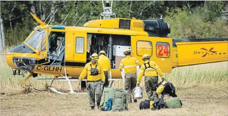  ?? NATHAN DENETTE
THE CANADIAN PRESS ?? Mexican fire rangers load their gear into a helicopter to help fight the Parry Sound 33 forest fire, which has burnt thousands of hectares of land.