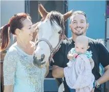  ??  ?? Charlene Frigon, left, Jacob Sheehy and their 4-month-old daughter KellyAnn have fun with Frigon’s horse Sunshine outside their campsite at the St-Tite Western Festival on Wednesday.