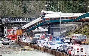  ?? AP/ELAINE THOMPSON ?? Rail cars from a wrecked Amtrak train are removed in December from a bridge over Interstate 5 near DuPont, Wash. The National Transporta­tion Safety Board released a report on the accident Thursday.