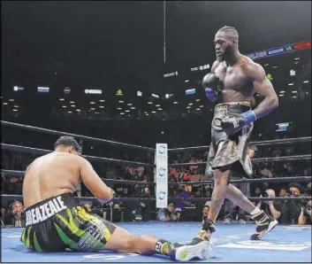  ?? Frank Franklin II The Associated Press ?? WBC heavyweigh­t champion Deontay Wilder dances in front of floored Dominic Breazeale in the first round of their title fight Saturday in New York.