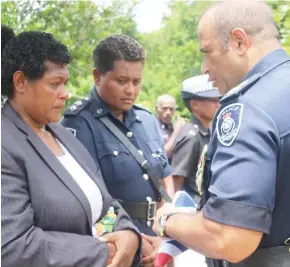  ?? Photo: Police Media Cell ?? Commission­er of Police Brigadier-General Sitiveni Qiliho (right), presents the Fijian flag to the wife of the late Constable Tevita Tukana, Adi Litiana Tukana.
