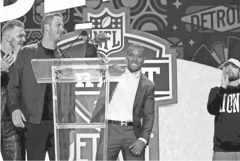  ?? ERIC SEALS/DETROIT FREE PRESS ?? From left, Lions Aidan Hutchinson, Jared Goff and Amon-Ra St. Brown along with Eminem pump up the crowd for the start of the NFL draft in Detroit on Thursday.