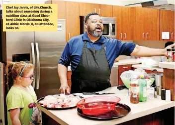  ??  ?? Chef Jay Jarvis, of Life.Church, talks about seasoning during a nutrition class at Good Shepherd Clinic in Oklahoma City, as Abbie Morris, 8, an attendee, looks on.