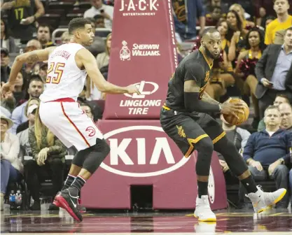  ??  ?? CLEVELAND: Cleveland Cavaliers’ LeBron James, right, spins towards the basket as Atlanta Hawks’ Thabo Sefolosha (25) defends during the second half of an NBA basketball game in Cleveland, Tuesday. The Hawks won 110-106. — AP