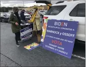  ?? JEFF AMY — THE ASSOCIATED PRESS ?? Volunteers assemble signs before a rally for Democratic U.S. Senate candidate Jon Ossoff and former U.S. Secretary of Housing and Urban Developmen­t Julian Casto in Lilburn, Ga., on Monday.