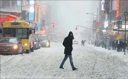  ?? CARLO ALLEGRI / REUTERS ?? Un hombre cruza la calle en plena tormenta en Times Square (Nueva York)