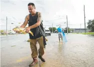  ?? Jay Janner, Austin AmericanSt­atesman via The Associated Press ?? Javier (no last name given) catches a carp in the middle of Brittmoore Park Drive in west Houston after the Addicks Reservoir overflowed due to days of heavy rain after Hurricane Harvey on Aug. 29, 2017.