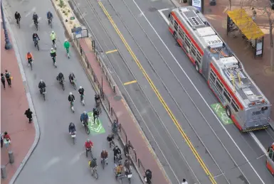  ?? Photos by Jessica Christian / The Chronicle ?? Cyclists mobilized by the San Francisco Bicycle Coalition ride en masse down Market Street on the first day of private cars being banned on this stretch of Market. “The city is changing,” said Mayor London Breed.