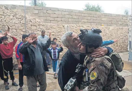  ?? MARKO DROBNJAKOV­IC / AP ?? Un hombre besa a un soldado de las fuerzas especiales iraquíes después de que inspeccion­aran su casa, en el barrio de Gogjali, en Mosul
