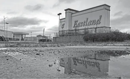  ?? ERIC ALBRECHT/COLUMBUS DISPATCH ?? The sign on the north side of Eastland Mall is reflected in an empty parking lot. The 43232 ZIP code, which includes the mall, leads the city in eviction filings and requests for rental aid during the pandemic.