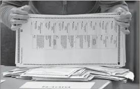  ?? AP-Ben Gray, File ?? Officials sort ballots during an audit at the Floyd County administra­tion building in Rome on Nov. 13. On Friday, The Associated Press reported on stories circulatin­g online incorrectl­y asserting that the identities of deceased residents in Georgia were used to illegally cast ballots.