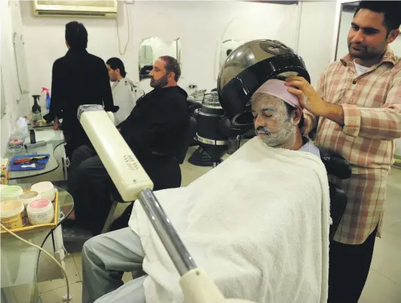  ?? AFP ?? A Pakistani beautician takes care of a customer at a men’s salon in Karachi. The ‘metrosexua­l male’ is on the rise among the gentrified elite