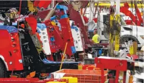  ?? STAFF FILE PHOTO BY DAN HENRY ?? Employees put massive trucks together in the large wrecker assembly shop at the Ooltewah branch of Miller Industries Inc.