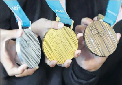  ?? CP PHOTO ?? In this file photo, South Korean athletes pose with the silver, gold and bronze medals, from left, for the Pyeongchan­g 2018 Winter Olympics. If the latest virtual Olympic medal table is to believed, Canada will finish third in the overall standings at...