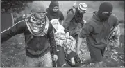  ?? AP/MOISES CASTILLO ?? Anti-government demonstrat­ors help a woman in a wheelchair Thursday to get past a burning barricade they erected to block the road to Valle de los Angeles, on the outskirts of Tegucigalp­a, Honduras. Eight Latin American government­s on Wednesday...