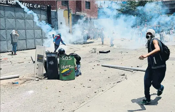  ?? RONALDO SCHEMIDT / AFP ?? Los opositores devuelven los botes de humo que lanza la policía venezolana en el centro de Caracas