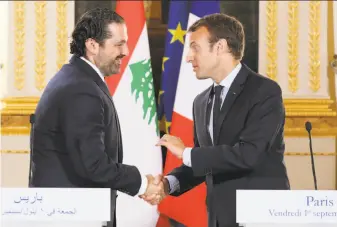  ?? Ludovic Marin / Associated Press ?? French President Emmanuel Macron (right) welcomed Lebanese Prime Minister Saad Hariri in September in Paris. Hariri has accepted an invitation to come to France in the next few days.