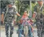  ?? PTI ?? Security personnel assist a specially abled voter in Balurghat on Friday.