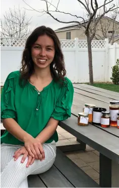  ??  ?? Olive & Co. founder Madison Anderholt shows off honey that is available for purchase on her website.