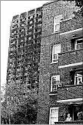  ?? KIRSTY WIGGLESWOR­TH/AP ?? A woman looks from her balcony near the remains of Grenfell Tower in London.