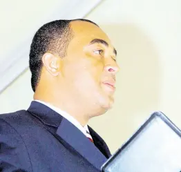  ?? FILE ?? Dr. Christophe­r Tufton holds the Bible aloft during his swearing-in as a Cabinet minister in the Bruce Golding administra­tion at King’s House in 2007.