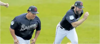  ?? CURTIS COMPTON/AP ?? Atlanta pitchers Bartolo Colon, left, and R.A. Dickey race during a workout Wednesday in Lake Buena Vista, Fla.