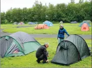  ?? EGILL BJARNASON / ASSOCIATED PRESS ?? Swiss tourists Etienne Evequoz and Celine Evequoz pitch a tent at the Laugardalu­r campsite in Reykjavik, on July 2.