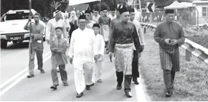  ??  ?? ZAMZURI (dua kanan) bersama peserta pertama berarak menuju ke Masjid Pandasan.