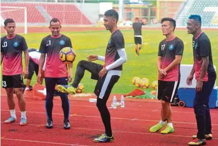  ?? PIC BY NAZIRUL ROSELAN ?? Pahang players share a light moment prior to a training session at the Temerloh Stadium yesterday.