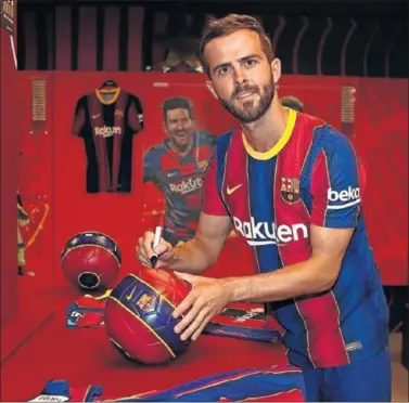  ??  ?? Miralem Pjanic firma un balón del Barça durante su presentaci­ón.
