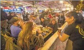  ?? Mel Melcon Los Angeles Times ?? CUSTOMERS dine outdoors at Cronies Sports Grill in Agoura Hills on Monday, hours after a state order put into place further coronaviru­s restrictio­ns.