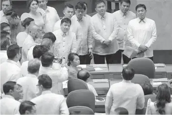  ?? PHILSTAR.COM ?? Former Philippine President Gloria Macapagal Arroyo, seated at center, is surrounded by other legislator­s at the House of Representa­tives on Monday. Arroyo, backed by dozens of allied legislator­s, took the main seat in the center stage of the House's plenary hall in a sign that she was taking over the post of Speaker.