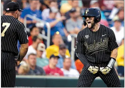  ?? AP/NATI HARNIK ?? Vanderbilt’s Philip Clarke (right) celebrates with teammate Walker Grisanti after crossing home plate following his home run in the seventh inning of the Commodores’ victory over Michigan on Tuesday night in Game 2 of the College World Series Championsh­ip Series. The teams meet tonight to determine the national champion.