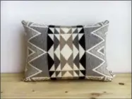  ?? SCOUT AND WHISTLE — ETSY VIA AP ?? This shows a southweste­rn-inspired geometric, wool pillow from Etsy shop Scout and Whistle. A desert storm is brewing in the design world. Renewed interest in earthy color palettes, rich textures, tribal patterns and rustic elements has sparked a revival of Southweste­rn decorating style, long associated with homes in New Mexico and Arizona.