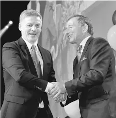  ??  ?? English (left) shakes hands with Peters during an election night event in Auckland. — Reuters photo