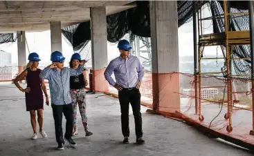  ?? Brett Coomer photos / Houston Chronicle ?? Developers Randall Davis, left, and Roberto Contreras walk with DeeAnn Thigpen, far left, and Natalie Davis through Arabella. When Arabella is completed later this year, it will have 99 luxury condos.