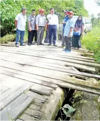  ??  ?? SADDI tinjau jambatan kayu yang perlu dibaiki untuk laluan membekal minyak.