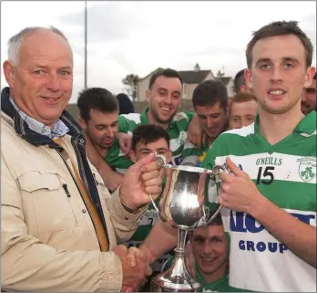  ??  ?? John Kavanagh of Shamrocks receives the cup after Sunday’s final from Ibar Murphy.