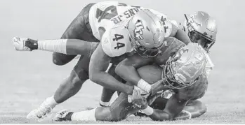  ?? MIKE CARLSON/AP ?? UCF’s Nate Evans (44) tackles South Florida’s Stanley Clerveaux during the Knights’ win over the Bulls in Tampa.