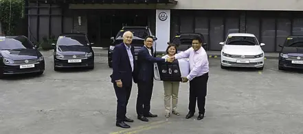 ??  ?? At the handover of the Polo Sedan, Touareg, and Passat units, Volkswagen Philippine­s’ Chief Operating Adviser Klaus Schadewald (left) with President and CEO Arthur Tan present the ceremonial key to DNS Treasurer Zaida Mago and President Rodolfo Mago.