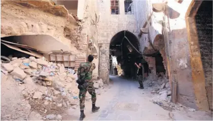  ?? AFP ?? Soldados del Gobierno sirio revisaron los daños ocasionado­s por un bombardeo en la ciudad de Alepo.