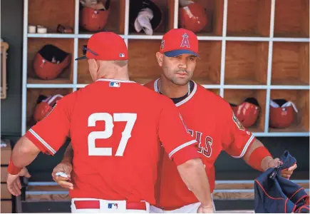  ?? MARK J. REBILAS/USA TODAY SPORTS ?? Angels DH-first baseman Albert Pujols, with Mike Trout (27) in the dugout, says, “I just know that I’m here. And my job is to put the uniform on and play. We’ll see what they want me to do.”