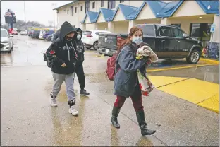  ?? (AP/David J. Phillip) ?? A family arrives at a Gallery Furniture store, which opened as a shelter, Wednesday in Houston.